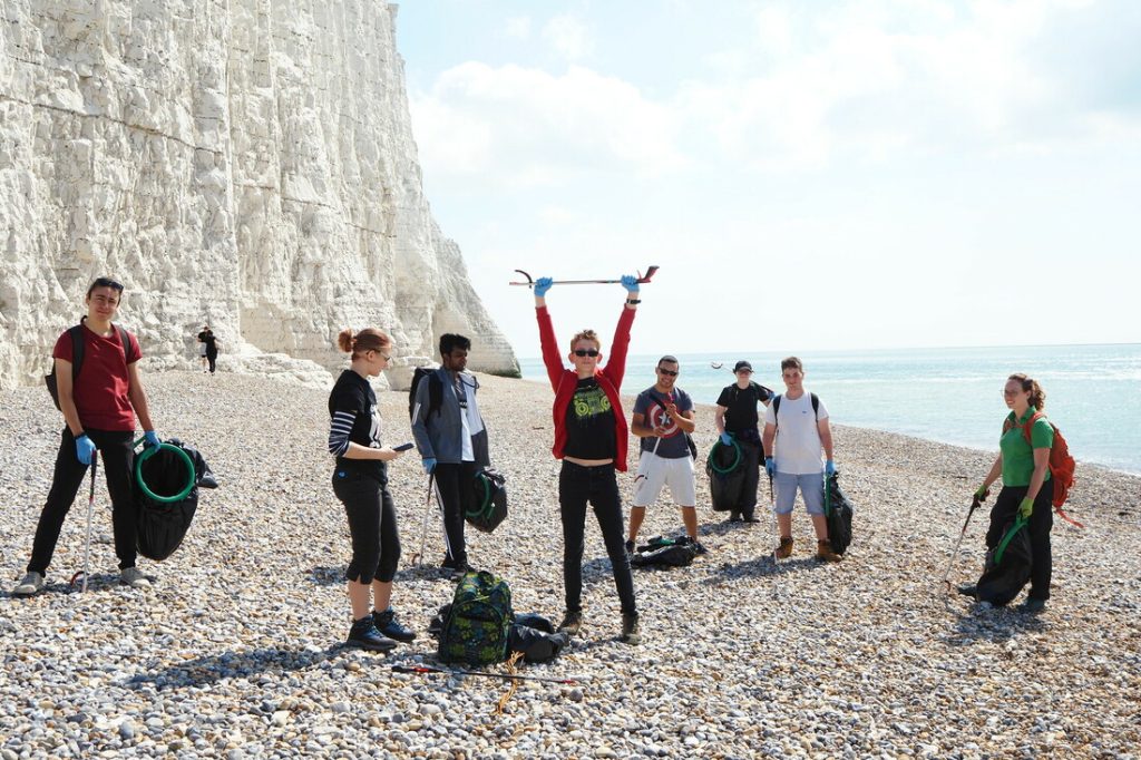 Young volunteers litter picking on the beach at Seven Sisdter Countyr Park