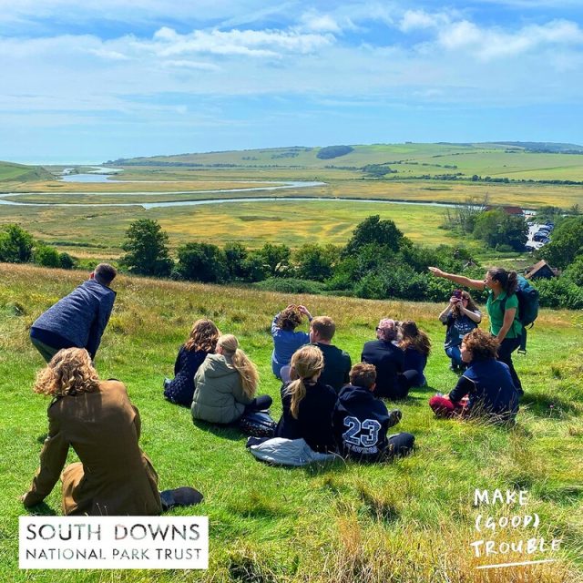 Holiday club with Make Good Trouble in East Sussex. Image shows young people looking at a view of the Cuckmere river at Seven Sisters