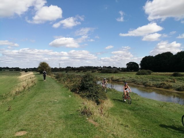 Walkers and cyclist next to the river Ouse in east sussex