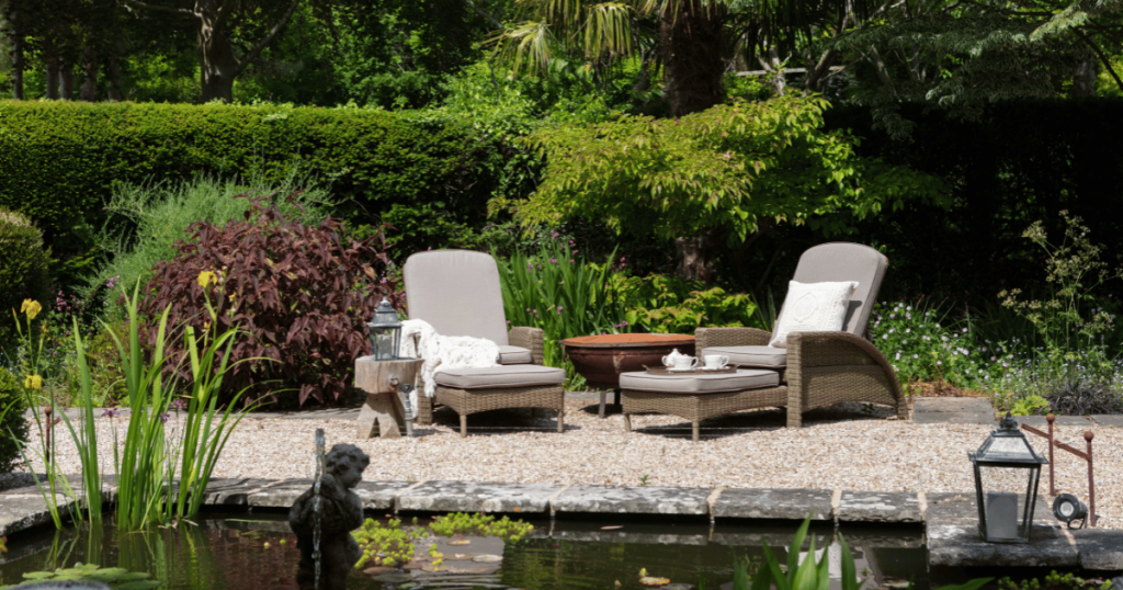 image showing two lounger chairs in a restful looking garden with a pond