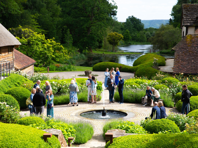 image shows people on a summer day enjoying the manicured gardens of Nyetimber vineyard during an exclusive open day for South Downs trust