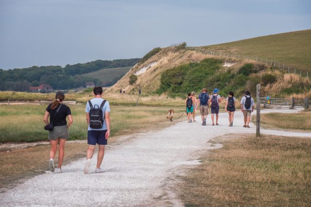 People in the summer walking along the easy access path at Seven Sisters country park